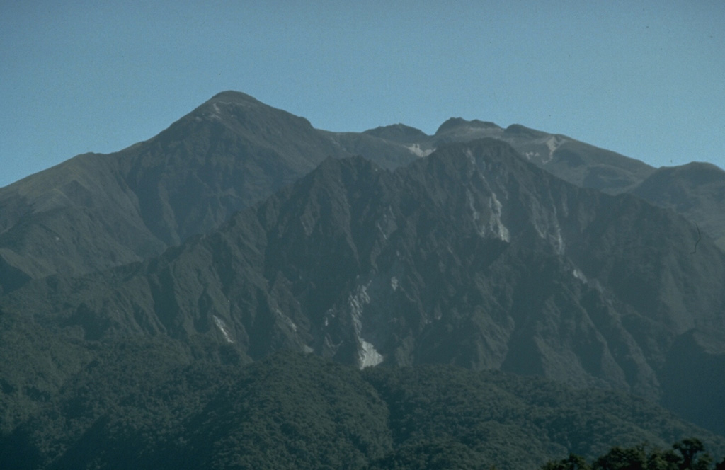 The Ninahuilca lava domes, which form the twin forested peaks below the right-center horizon, were created during an eruption about 2400 years ago.  Growth of the lava domes within the summit caldera of Atacazo volcano was accompanied by plinian explosive eruptions and pyroclastic flows that traveled 35 km down valleys to the west.   Photo by John Ewert, 1992 (U.S. Geological Survey).