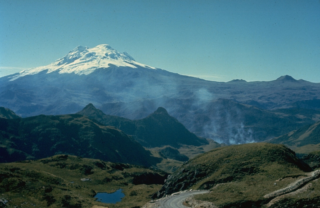The floor of the massive Chacana caldera is seen here in the foreground, looking SE with glacier-covered Antisana volcano in the distance.  Chacana is a 32 x 24 km caldera complex of Pliocene-Holocene age.  Its outer flanks extend over 50 km, making it one of the largest rhyolitic centers of the northern Andes.  Numerous lava domes were constructed within the caldera, which has been the source of frequent Holocene explosive eruptions.  Dacitic lava flows were erupted during the 18th century and numerous hot springs are found on the caldera floor. Photo by Minard Hall, 1976 (Escuela Politécnica Nacional, Quito).