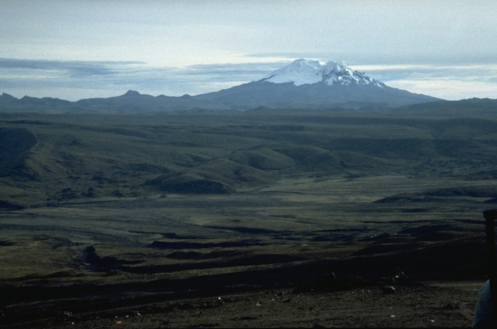 Massive, 5753-m-high Antisana volcano is seen here from its SW on the northern flank of Cotopaxi volcano.  The glacier-clad Antisana was constructed immediately SE of Chacana caldera, the largest rhyolitic center of the northern Andes, which lies beyond the jagged ridge left of Antisana.  The only unequivocal historical eruption of Antisana occurred in 1801-02 from a vent NNE of the summit.  Photo by John Ewert, 1992 (U.S. Geological Survey).