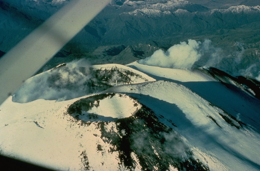 Steam clouds rise above two of three summit craters at Ecuador's Sangay volcano.  Continual eruptions since 1934 have frequently modified the morphology of the volcano's summit.  At the time of this 1976 view from the east, a lava flow from the southernmost crater (right) was descending the western flank. Photo by Gordon Armstrong, 1976 (courtesy of Minard Hall, Escuela Politécnica Nacional, Quito).