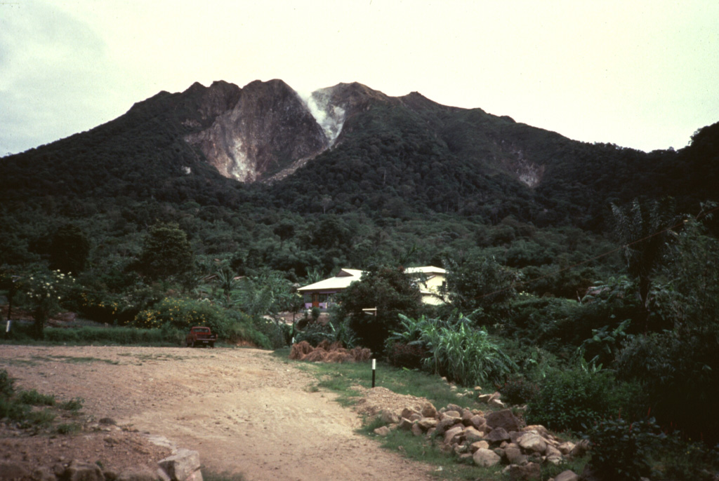 Gunung Sibayak, seen here from the S, is the southernmost of two volcanoes constructed within the Singkut caldera. Several villages occupy the flat-bottomed caldera floor. Plumes rise from fumaroles on the flank of a lava dome in the summit crater. Anonymous, 1990.
