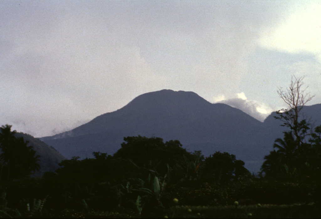 The summit of forested Gunung Talang volcano is seen here from the NW. Two crater lakes are on the flanks of the volcano and several flank eruptions took place during the 19th century. Anonymous, 1991.