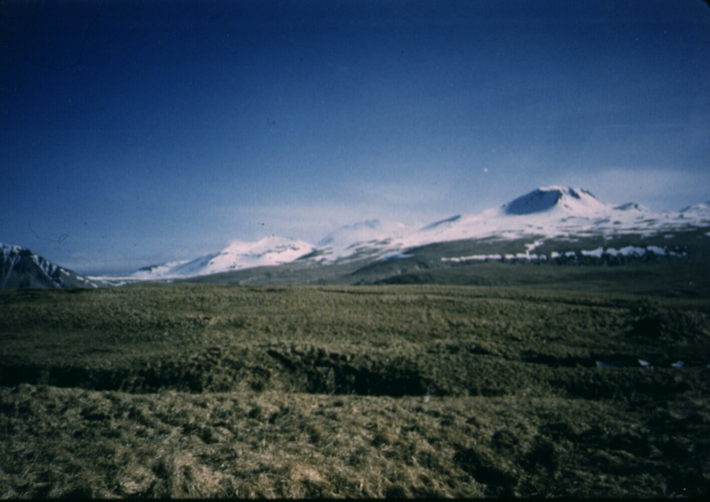 The Atka volcanic complex at the NE tip of Atka Island is one of the largest volcanic centers in the central Aleutians. It contains a caldera and is surrounded by 7 or 8 smaller cones. This view from the south near Atka village shows Korovin, the highest and northernmost of three Holocene cones of the Atka complex.  Photo by James Dickson, 1986 (courtesy of John Reeder, Alaska Div. Geology Geophysical Surveys).