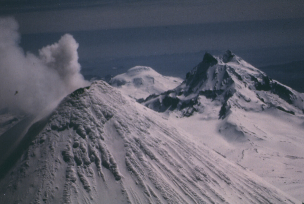 Unimak Island has three volcanoes constructed along an E-W line. Shishaldin is in the foreground and is the highest of the three in this 1987 photo. Isanotski is to the right and Roundtop is in the far distance. Photo by Clayton and Marcia Brown, 1987 (courtesy of John Reeder, Alaska Div. Geology & Geophysical Surveys).