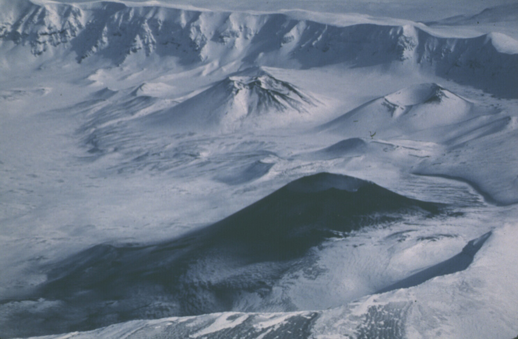 This 2 March 1987 view from the west shows the ash deposition on the flanks of a cone in the SW corner of Okmok caldera. Intermittent explosive eruptions took place from November 1986 to February 1988 from Cone A. Cone C and Cone F are visible in the background. Photo by Harold Wilson (Peninsula Airways), 1987 (courtesy of John Reeder, Alaska Div. Geological Geophysical Surveys).