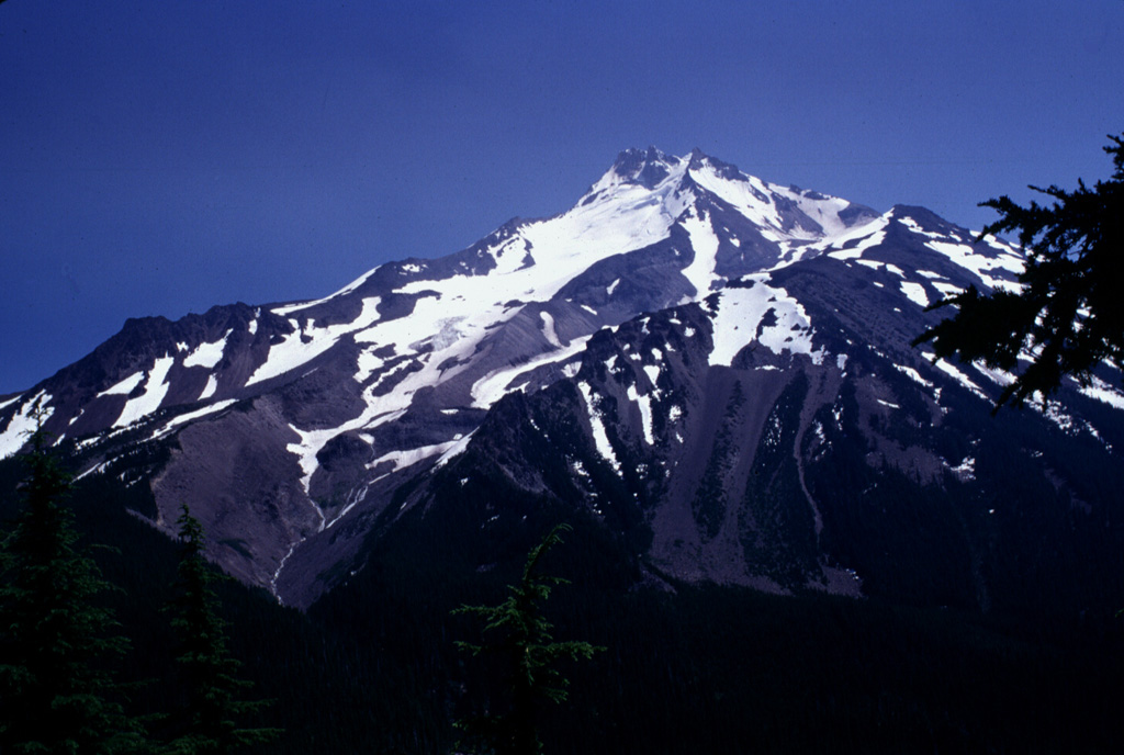 Deep glacial valleys cut the western flanks of Mount Jefferson. The original edifice was extensively eroded by glaciers prior to formation of a younger dacite cone on top of the older edifice. Lava dome growth was associated with the younger volcano and were accompanied by major ash-producing eruptions and pyroclastic flows, before activity ceased activity during the late Pleistocene. Photo by Lee Siebert, 1996 (Smithsonian Institution)