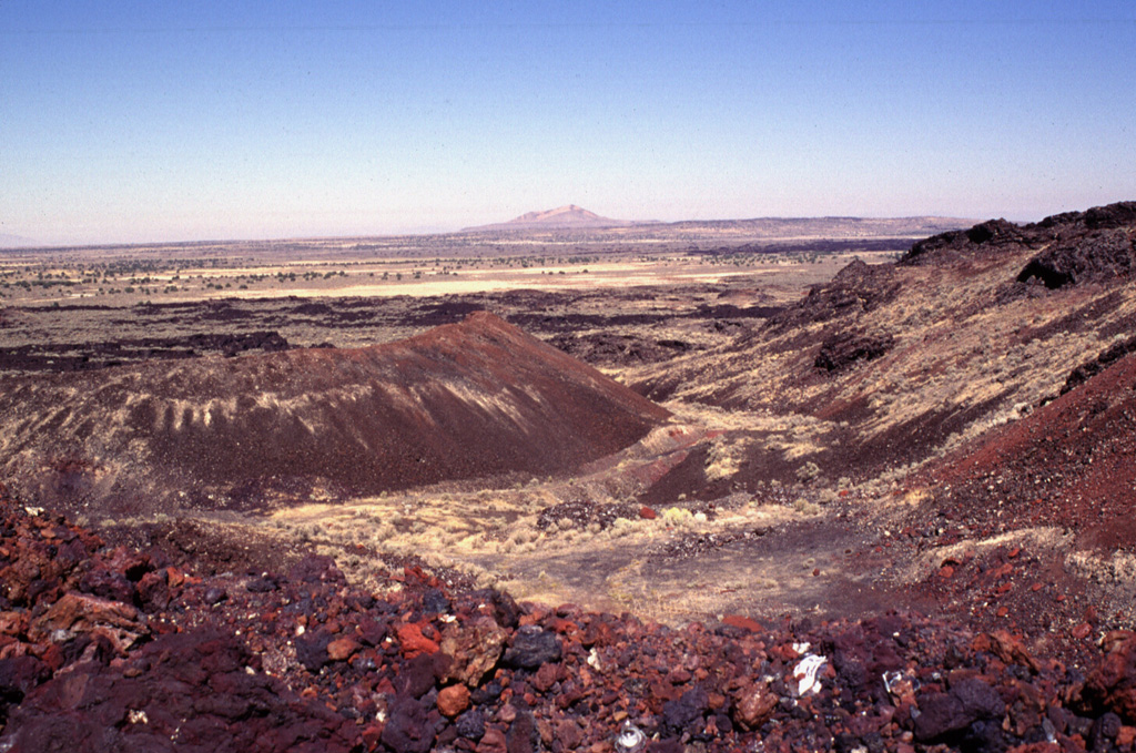 The Black Rock Desert volcanic field consists of a cluster of closely spaced small volcanic fields of Pleistocene-to-Holocene age in the Black Rock and Sevier deserts.  This view shows Utah's youngest known lava flow, the 660-year-old Ice Springs flow, which originated from a series of nested cinder and spatter cones.  The rim of Crescent Crater is at the right, with the symmetrical Pocket Crater at the left and Pavant Butte in the distance.  This tuff cone erupted through the waters of Pleistocene Lake Bonneville about 16,000 years ago. Photo by Lee Siebert, 1996 (Smithsonian Institution).