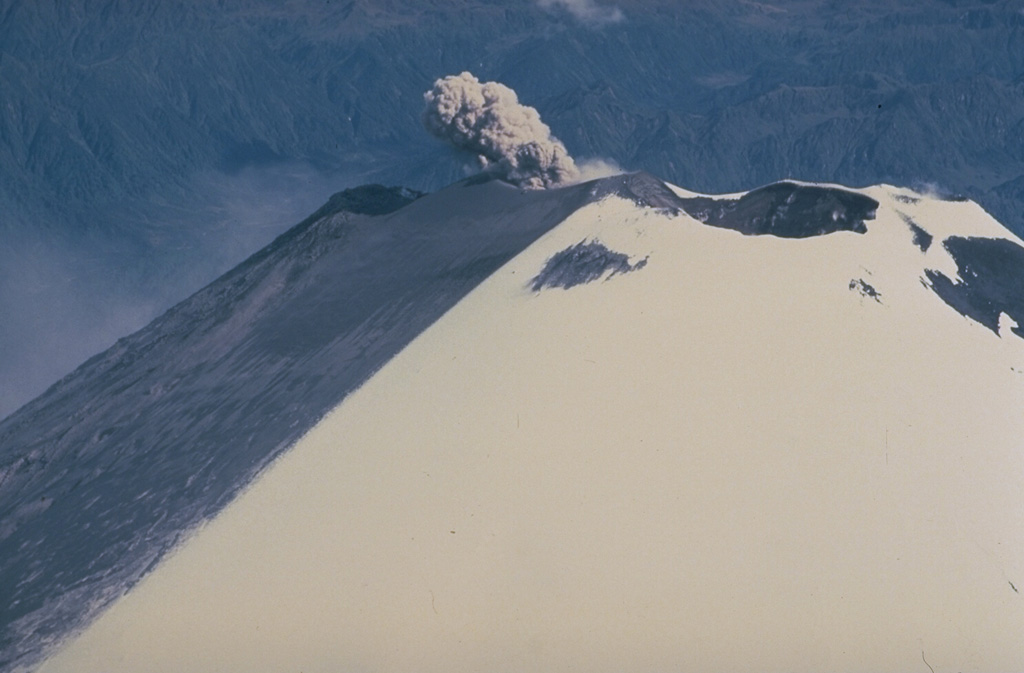 A small ash plume rises from the SW summit crater of Ecuador's Sangay volcano in September 1983 and ashfall darkens snow on the upper SW flank.  Almost continuous minor explosive activity has occurred since 1934, occasionally accompanied by the emission of short lava flows. Copyrighted photo by Katia and Maurice Krafft, 1983.
