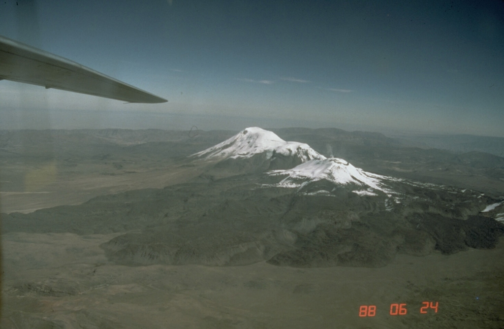 A dark-colored 15-km-wide apron of trachytic and dacitic lava flows surrounds 5967-m-high Sabancaya volcano.  The prominent lava flow at the left extends more than 10 km down the SSE flank.  Ampato volcano in the background forms the 6288-m high point of the Sabancaya volcanic complex.  Amapato and Hualca Hualca volcano (out of view to the right) have also erupted during the Holocene, but only Sabancaya has erupted in historical time. Photo by Norm Banks, 1988 (U.S. Geological Survey).