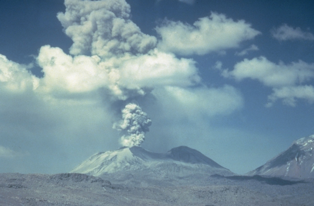 An ash-bearing plume rises above Sabancaya volcano in this photo taken from the NE, possibly in October, 1988.  Voluminous steam plumes, some with dark, basal "rooster-tails," were observed to have risen 0.5-1 km above the summit on June 22, 1988.  The northern flank of Ampato volcano rises at the far right. Photo by Minard Hall, 1988 (Escuela National Politecnica, Quito).