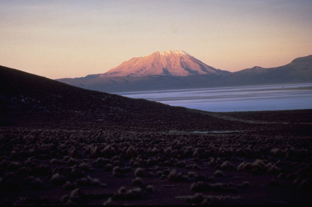 Volcán Ubinas, seen here from the west, is Perú's most active volcano.  A small, 1.2-km-wide caldera that cuts the top of Ubinas gives it a truncated appearance.  The upper slopes of the stratovolcano steepen to nearly 45 degrees.  The steep-walled, 150-m-deep caldera contains an ash cone with a 500-m-wide funnel-shaped vent that is 200-m deep.  Holocene lava flows are visible on the volcano's flanks, but historical activity, documented since the 16th century, has consisted of intermittent minor explosive eruptions.      Photo by Norm Banks, 1988 (U.S. Geological Survey).