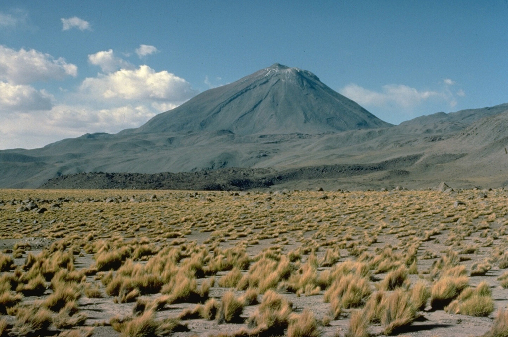 The symmetrical, 5916-m-high Volcán Licancabur stratovolcano contains one of the world's highest lakes in its 400-m-wide summit crater.  Archaeological ruins are located on the crater rim.  Young lava flows with prominent levees extend up to 6 km down the NW-to-SW flanks.  Most of the morphologically youthful volcano was constructed during the Holocene.  The pre-Holocene Juriques volcano is located immediately to the SE and is capped by a 1.5-km-wide summit crater.   Copyrighted photo by Katia and Maurice Krafft, 1983.