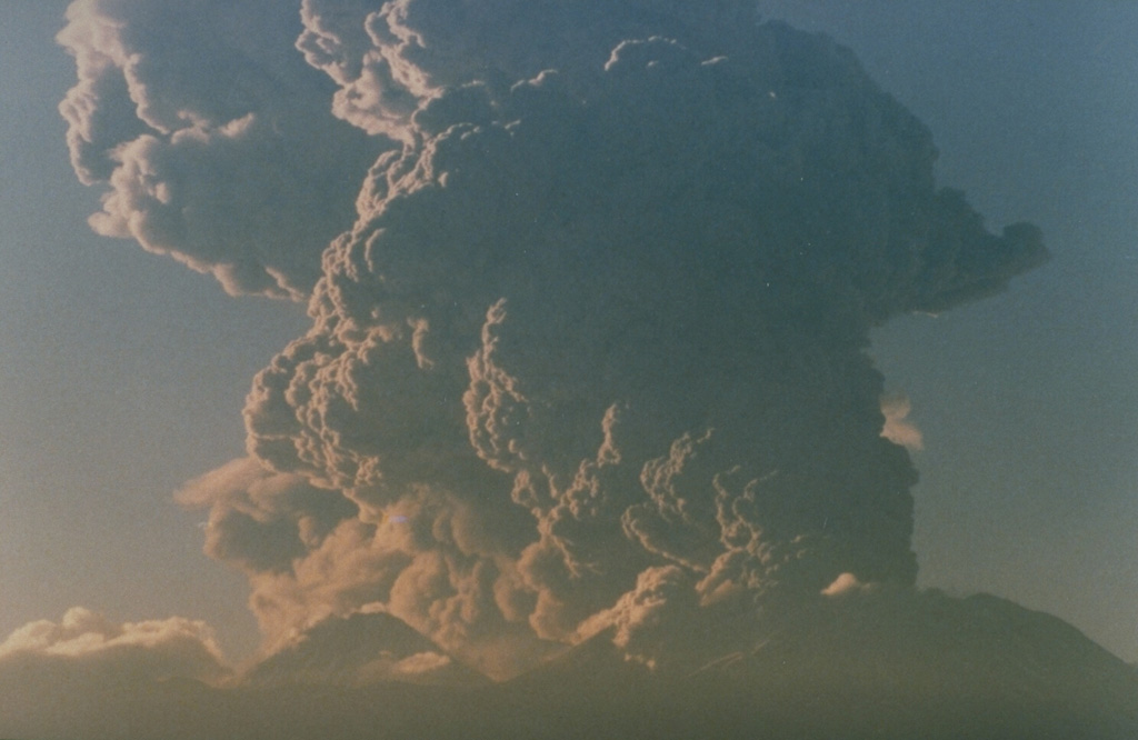 Following minor eruptions on September 14 and 15, 1986, a strong explosive eruption from Láscar volcano on September 16 deposited ash 350 km away at Salta, Argentina.  The eruption cloud, seen here at about 7:30 a.m. from Toconao, 33 km to the NW, rose to 15 km altitude (about 9 km above the vent), producing an ash column that dispersed to the SE.  The plume was traced on satellite imagery to about 400 km downwind and covered an area of more than 112,000 sq km.  The brief eruption ended on the 16th. Photo by Paul King, MINSAL Corporation, 1986 (courtesy of Peter Francis, Open University).