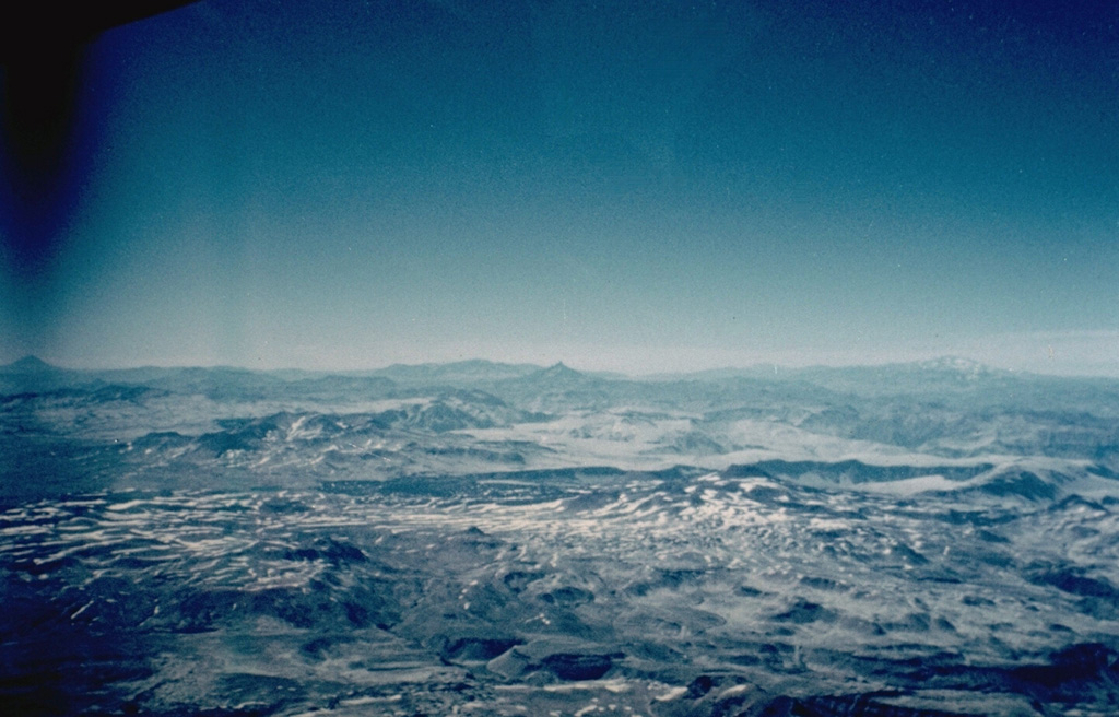 The 26 x 14 km late-Pleistocene Calabozos caldera contains several post-caldera vents of Holocene age.  The Descabezado Chico group (mid right-center) was constructed over the buried western rim of the caldera.  The Cerro de Medio group (mid extreme-right) grew within the southern part of the caldera.  No historical eruptions are known, but hot-spring clusters occur within the caldera. Photo by Hugo Moreno (University of Chile).