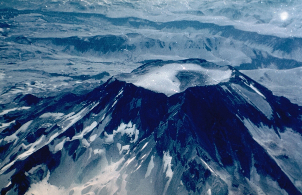 The summit of Descabezado Grande volcano is truncated by a 1.4-km-wide, ice-filled summit crater, giving rise to its name, which means "Large Headless Volcano."   The only historical eruption of this late-Pleistocene to Holocene volcano, seen here from the west, occurred in 1932 from an upper NNE-flank vent.  The 1932 crater lies out of view below and to the left of the notch at the left side of the summit crater. Photo by Hugo Moreno (University of Chile).