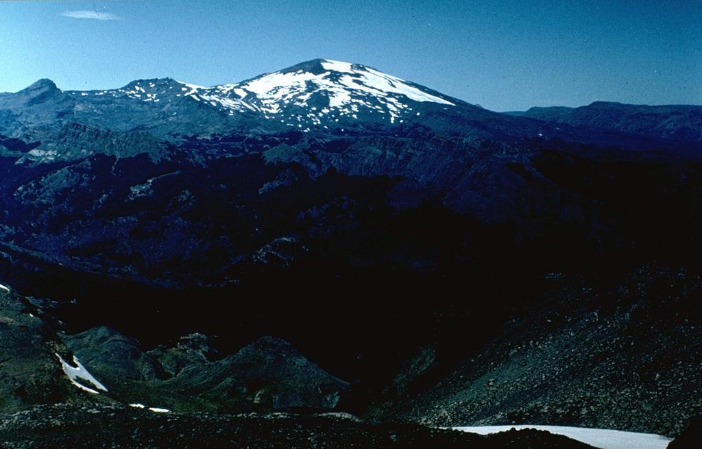 Volcán Copahue is a composite volcano constructed along the Chile-Argentina border within an 8-km-wide Pleistocene caldera.  The eastern summit crater, part of a 2-km-long, ENE-WSW line of nine craters, contains the briny El Agrio crater lake and displays intense fumarolic activity.  Infrequent explosive eruptions have been recorded since the 18th century from the 2965-m-high volcano.    Photo by Hugo Moreno (University of Chile).