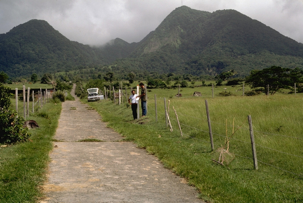 Gage's Mountain (left) and Chance's Mountain (right), seen here from the west in 1985, are the NW-most of a series of lava domes forming the summit of Soufrière Hills volcano.  They are among the oldest of the summit domes, and were formed during the late Pleistocene.  Pyroclastic flows that reached Plymouth in 1997 traveled down Gage's Ghaut, the valley between the two lava domes. Photo by Richard Fiske, 1985 (Smithsonian Institution).