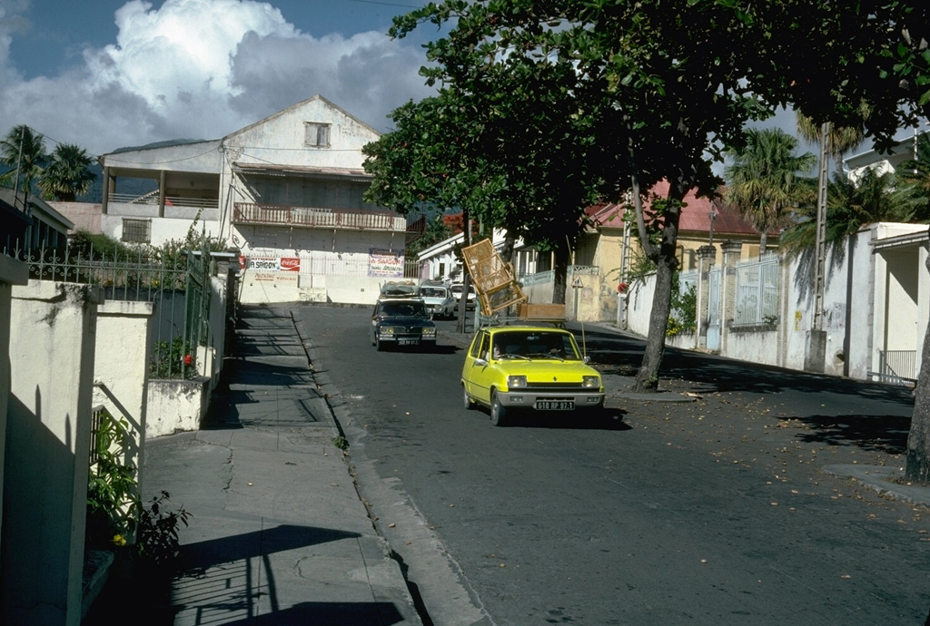 Vehicles laden with possessions are driven down the streets of Basse-Terre in September 1976, during the evacuation of the island's capital city.  About 72,000 people living on the slopes of the volcano were evacuated until November 1976, producing significant economic disruption. Photo by Richard Fiske, 1976 (Smithsonian Institution).