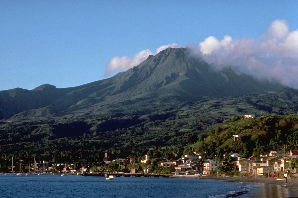 Mount Pelee, the most renowned volcano of the West Indies, towers above the city of St. Pierre, which it destroyed during a major eruption in 1902.  Pelee is the most active volcano of the Lesser Antilles, producing at least 20 major explosive eruptions during the past 5000 years.  Extensive deposits of pyroclastic flows mantle the volcano.  Its present summit consists of lava domes emplaced during eruptions in 1902 and 1929.   Copyrighted photo by Katia and Maurice Krafft, 1988.