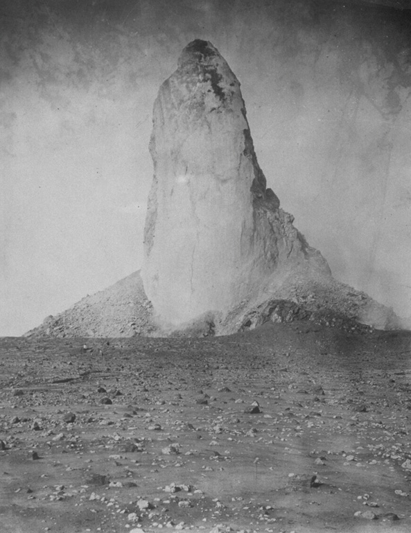 Slow, piston-like extrusion of a solidified portion of a lava dome sometimes produces vertical lava spines that rise above the surface of the dome.  The world's largest known spine rose to a maximum height of 350 m, more than twice that of the Washington Monument, at Mount Pelee on Martinique in 1903.  Growth of the spine began in November 1902 and reached its maximum on May 31, 1903.  It slowly disintegrated and was gone by the end of the eruption two years later.  This photo was taken on March 15, 1903. From the collection of Maurice and Katia Krafft.