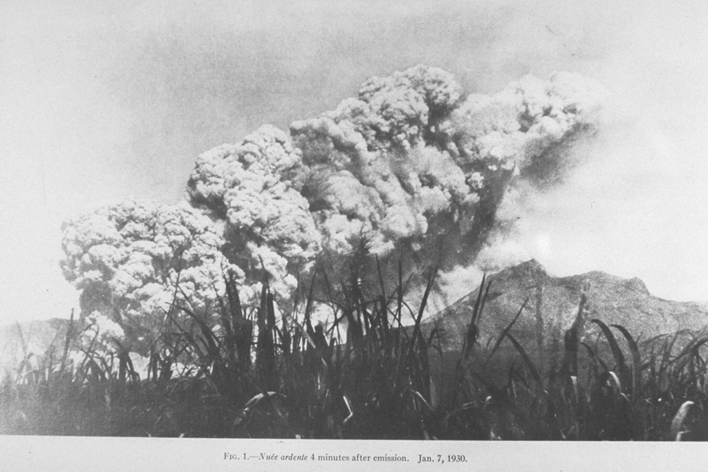 A pyroclastic flow produced by the collapse of a growing lava dome in the summit crater, sweeps down the SW flank of Mount Pelee on 1 January 1903.  Small pyroclastic flows continued for 16 months following the catastrophic eruption of 8 May 1902, that destroyed St. Pierre.  A second large pyroclastic flow, comparable in size to that of 8 May, devastated the SE flank on 30 August, killing an additional 1500 people.  The frequency of pyroclastic flows diminished after September 1903, but they continued at longer intervals until October 1905. Photo by Hayot, 1903 (from the collection of Maurice and Katia Krafft).