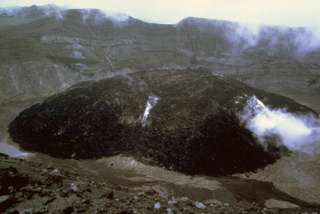 A lava dome 130 m high and more than 840 m wide filled much of the crater floor of Soufrière St. Vincent volcano during the 1979 eruption. Dome growth began in May, after a series of powerful explosive eruptions 13-15 April, and continued until October. Steam continued to rise from the dome in this 1983 photo from the SW crater rim. Photo by Richard Fiske, 1983 (Smithsonian Institution).