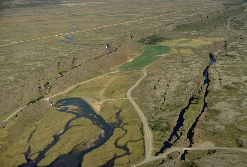 An aerial perspective of Thingvellir, the site of Iceland's historical outdoor parliament, shows the NE-SW-trending Almannagjá fissure cutting diagonally across the left side of the photo.  Other prominent fissures cutting lavas of the Hengill volcanic system appear at the right.  The Logberg, or law-hill (located at the lower left below the 30-40 m high Almannagja fissure) was the site where the laws of the country were proclaimed during the annual two-week-long parliamentary session in late June and early July. Copyrighted photo by Katia and Maurice Krafft.