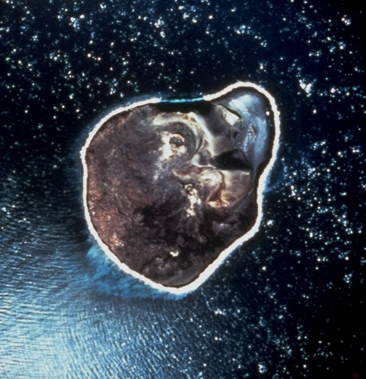 An April 1968 vertical aerial photo shows the ~2-km-wide island of Surtsey, less than one year after eruptive activity ceased. This island was formed during eruptions from November 1963 until June 1967 CE. Initial submarine eruptions rapidly produced a new island that became permanent after lava effusion began in 1964. The remains of two cinder cones and associated craters can be seen in the northeast (top) of the island. Several other ephemeral islands around Surtsey that were not armored by lava are now eroded beneath the ocean surface. Photo by National Aeronautical and Space Administration (NASA), 1968.