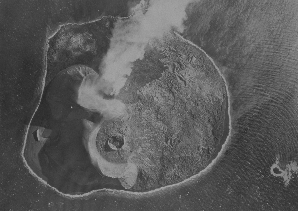 The island of Surtsey, seen here from the NW, developed during an eruption from 1963 to 1967 CE. This 1966 photo shows an active eruption from the floor of the Surtur cone (top), with a small steam plume towards the SE and fresh dark lavas on the eastern side of the island (top). The circular Surtungur vent (bottom cone), and its contiguous lava shield to the south were formed in 1964-65 during a period of lava effusion. Photo by Icelandic Survey Department, 1966 (published in Green and Short, 1971).