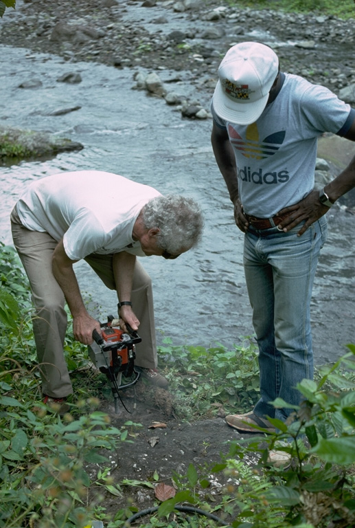 Volcanologists Richard Fiske and Keith Rowley drill a boulder on the east flank of Soufrière St. Vincent volcano to install benchmarks for deformation surveys.  These surveys allow detection of inflation of the volcano that often occurs prior to eruptions. Photo by John Shepherd, 1989 (University of West Indies).