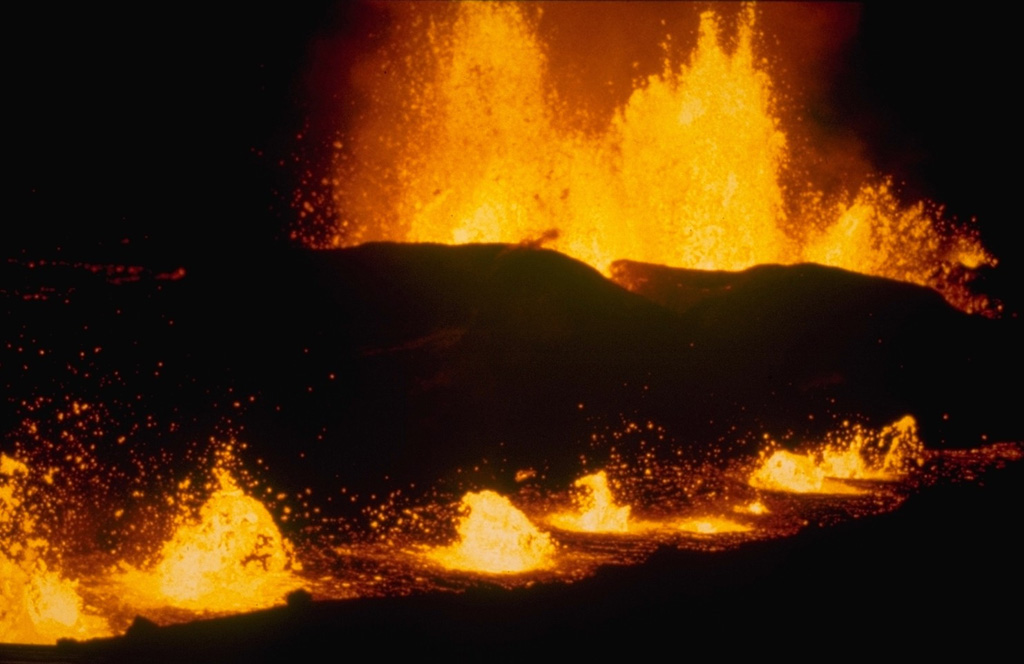 The last phase of the 1980 Krafla eruption began on 18 October, after a three-month period of quiescence. By the second night of the eruption, photographed here, activity was concentrated along two parallel eruptive fissures. Powerful lava fountains rose above the background fissure. The fissure in the foreground was less active but contained an elongated lava pond above which a row of small lava fountains formed. Photo courtesy of Gudmundar Sigvaldason, 1980 (Nordic Volcanological Institute, Reykjavik).