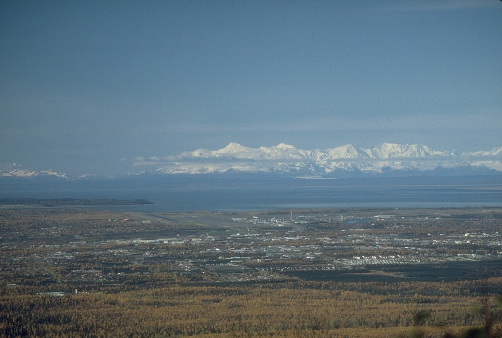 Mount Spurr is visible on the skyline 125 km W of Anchorage, Alaska. In 1992 three brief explosive eruptions from the Crater Peak vent deposited several millimeters of ash over south-central Alaska and on one occasion forced the closure of Anchorage International Airport for 20 hours. Photo by Game McGimsey, 1988 (Alaska Volcano Observatory, U.S. Geological Survey).