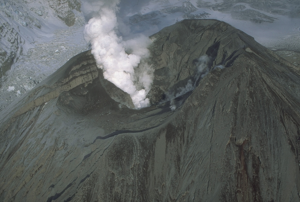 Following the three eruptions of 1992, the interior of the Crater Peak vent at Mount Spurr contained tens of meters of new eruption deposits. All traces of the former lake had disappeared. A plume of steam and volcanic gas continued from the vent for several years. This photo was taken on 26 September, nine days after the eruption ended. Photo by Cynthia Gardner, 1992 (U.S. Geological Survey).
