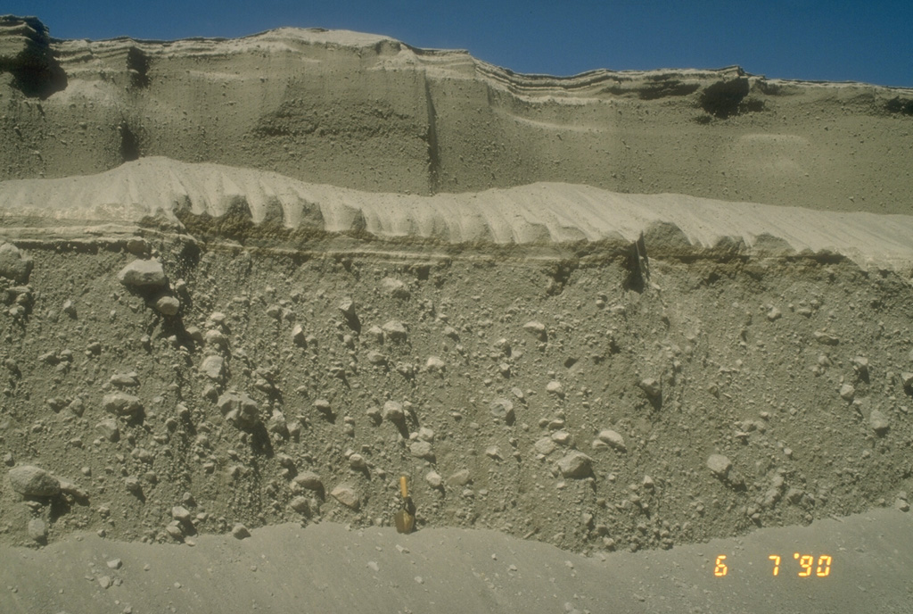 Pyroclastic flow deposits from the 15 April (lower 2/3 of section) and 21 April (upper 1/3 of section), 1990 eruptions of Redoubt in Alaska are exposed in a gully. The shovel at the base of the section provides scale. The larger 15 April pyroclastic flow carried large blocky fragments of a lava dome that had been growing in the summit crater. Photo by Christina Neal, 1990 (Alaska Volcano Observatory, U.S. Geological Survey).