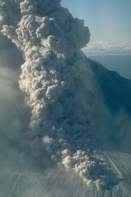 A pyroclastic flow travels down the north flank of Augustine volcano in Alaska on 30 March 1986, three days after the start of a five-month long eruption. An ash plume rises above the pyroclastic flow. As with many Augustine eruptions, early pyroclastic flows were pumice rich; later in the eruption block-and-ash flows were produced by collapse of a growing lava dome. Photo by Betsy Yount, 1986 (Alaska Volcano Observatory, U.S. Geological Survey).