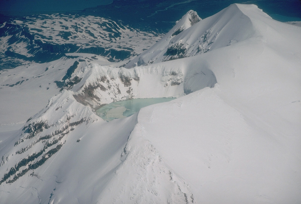 The summit of Douglas volcano on the northern tip of the Alaska Peninsula contains a warm and highly acidic crater lake approximately 160 m wide. An active fumarole field is also found on the shores of the lake. Photo by Christina Neal (Alaska Volcano Observatory, U.S. Geological Survey).