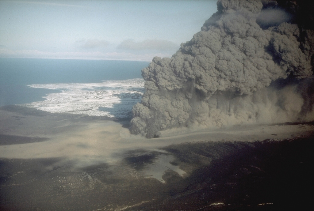 The interaction of magma with groundwater produced this dark, ash-rich eruption column in 1977 from the Ukinrek Maars on the Alaska Peninsula. The eruption occurred in an area without previous volcanic activity, through surficial glacial deposits. The phreatomagmatic explosions created two new craters, which were named after the Yupik words for "two holes in the ground." This photo was taken from the WSW on 6 April 1977. Photo by R. Russell, 1977 (Alaska Department of Fish and Game).