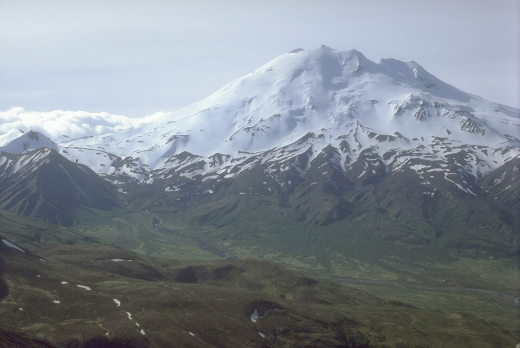 Chiginagak is a glacier-covered edifice with hot springs near the base of the N flank. Recent eruption products include an unglaciated lava flow and an overlying block-and-ash-flow deposit on the east side.  Photo by Alaska Volcano Observatory, U.S. Geological Survey