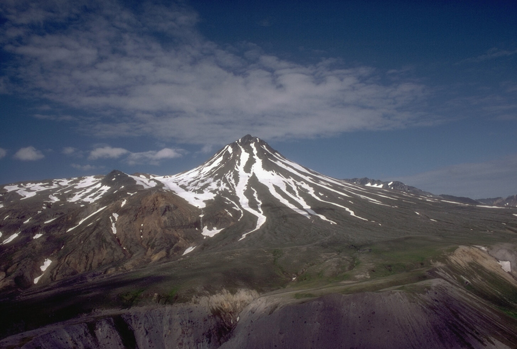Yantarni is located on the Alaska Peninsula, with this view from the east showing the lava dome at the summit. On either side of the dome are remnants of a large crater that opens to the NE, which formed during flank collapse about 2,000-3,500 years ago. Photo by Tom Miller, 1985 (Alaska Volcano Observatory, U.S. Geological Survey).