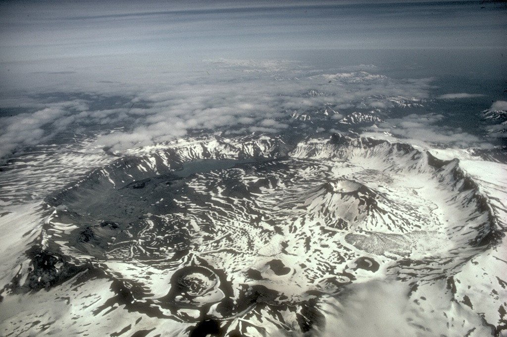 Aniakchak is a 10-km-wide summit caldera containing numerous cones, lava domes, and lava flows on the caldera floor. The largest intra-caldera cone is Vent Mountain that reaches 430 m in height and has a diameter at the base of 2.5 km. At least 20 Holocene eruptions may have occurred before the Aniakchak II caldera-forming eruption. Photo by M. Woodbridge Williams (National Park Service).