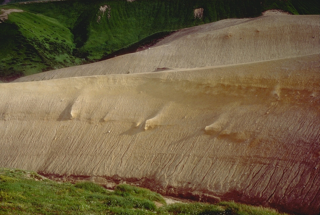 This outcrop exposes a thick pyroclastic flow deposit from an eruption that formed a small caldera on the eastern edge of Black Peak volcano. This major eruption occurred about 4,200 to 4,700 years ago and filled adjacent valleys to depths of up to 100 m. Photo by Tom Miller, 1985 (Alaska Volcano Observatory, U.S. Geological Survey).