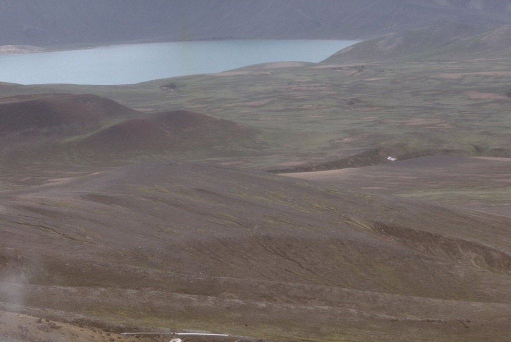 This 1974 view shows part of the interior of Fisher caldera on Unimak Island in the eastern Aleutian Islands. Fisher is an 11 x 18 km caldera that formed about 9,100 years ago during the eruption of pyroclastic flows that overtopped topographic barriers more than 500 m high. The caldera contains several lakes, maars, and other vents. Photo by Tom Miller, 1974 (Alaska Volcano Observatory, U.S. Geological Survey).