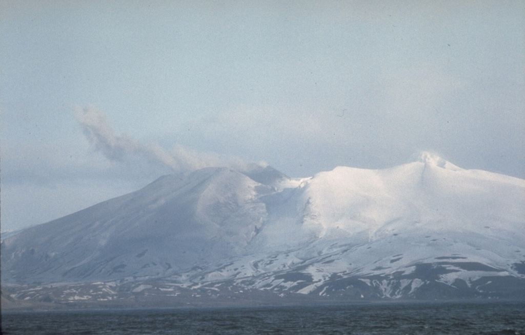 Akutan forms the west-central part of Akutan Island in the eastern Aleutians. The summit contains a 2-km-wide caldera with a large scoria cone, visible here through a low point in the northern caldera rim. The cone has been the site of frequent historical eruptive activity. Photo courtesy of U.S. Geological Survey, Alaska Volcano Observatory.