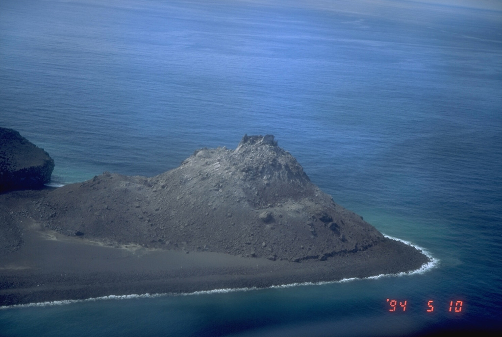 An aerial view shows the 1992 lava dome of Bogoslof Island, the summit of a largely submarine located in the Bering Sea 50 km behind the main Aleutian arc. The 1992 lava dome grew to a height of 100 m in July at the northern tip of the island. In May 1994, when this photograph was taken, the island was about 1.5 x 0.6 km wide, and due to frequent eruptive activity and energetic wave action, has changed shape dramatically since first mapped in the late 1700's. Photo by Tom Miller, 1994 (Alaska Volcano Observatory, U.S. Geological Survey).