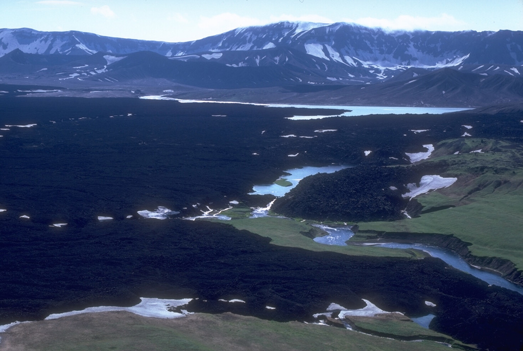 Lava flows cover large parts of the Okmok caldera floor on NE Umnak Island, some of which erupted during historical time. The small lakes within the caldera are remnants of a larger lake that filled the caldera to depths of more than 200 m before overtopping the rim and eroding a 180-m-deep notch through the northern caldera wall. Photo by Chris Nye, 1980 (Alaska Division of Geological & Geophysical Surveys, Alaska Volcano Observatory).