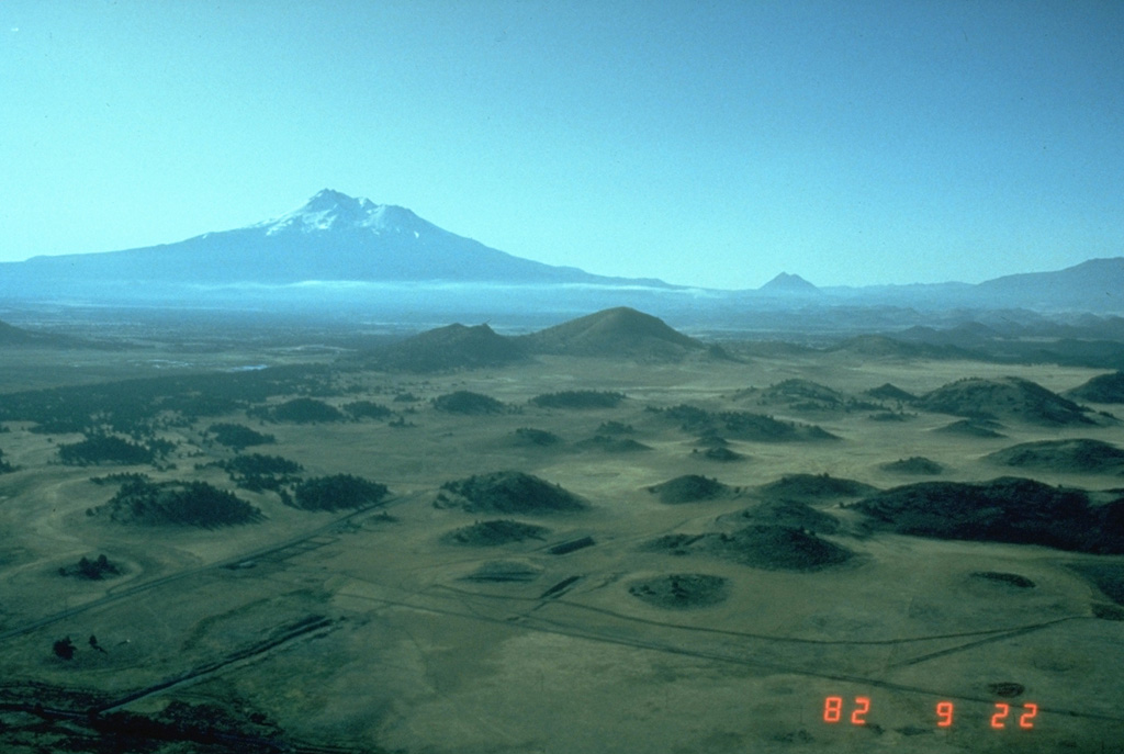 The hilly topography in the foreground is part of the massive debris avalanche deposit produced by collapse of Mount Shasta (in the background) during the Pleistocene. These hummocks represent relatively intact blocks of the volcano that were carried within a more mobile landslide matrix (smaller blocks and grains, snow and ice, and anything entrained during transportation). The debris avalanche covered an area of about 675 km2, reaching at least 45 km NNE. Photo by Harry Glicken, 1982 (U.S. Geological Survey).