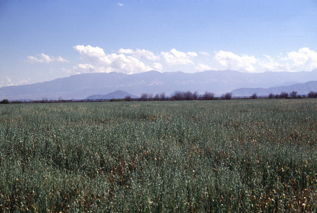 The flat-topped summit of Las Cumbres volcanic complex, a Quaternary volcano NNE of Pico de Orizaba, is seen here from the NW across the Serdán-Oriental basin. A 3.5-4.5 km wide summit caldera is partially filled by the Cerro Gordo lava dome. At least one of a group of monogenetic cones, craters, and lava domes on the flanks of the volcano is of Holocene age. Photo by Lee Siebert, 1997 (Smithsonian Institution).