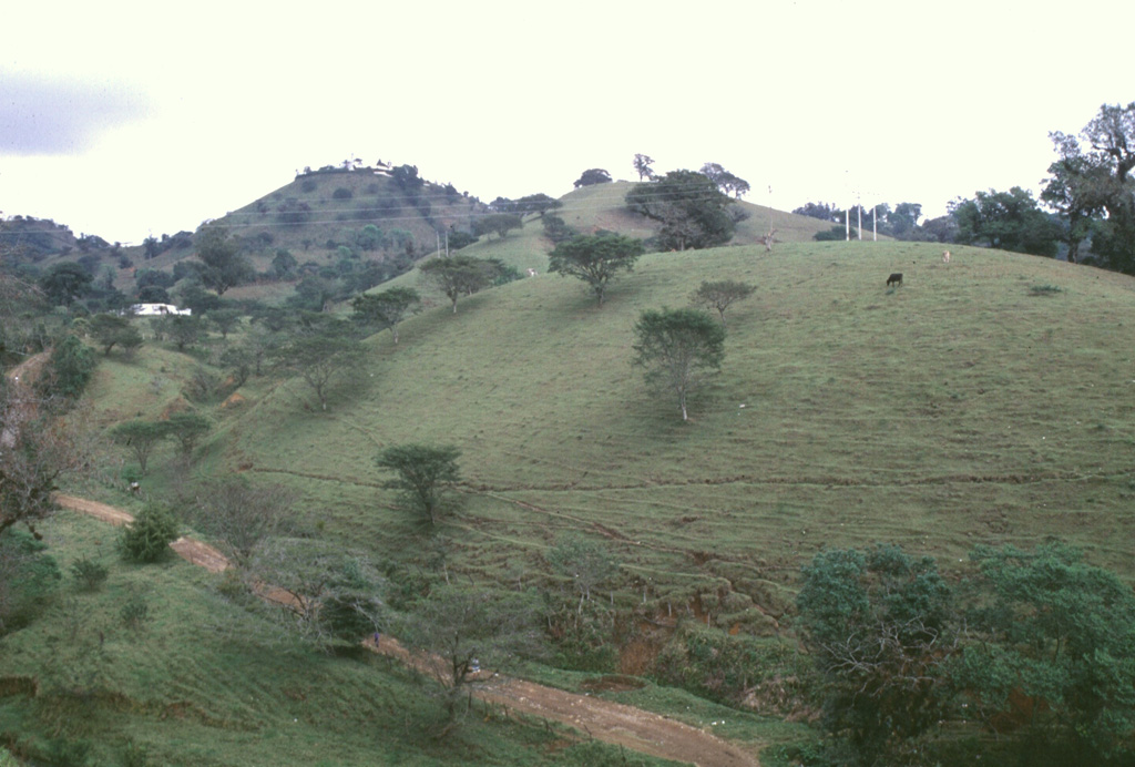These large hills on the outskirts of the city of Huatusco, 35 km from Orizaba, are hummocks of the Jamapa debris avalanche and debris flow deposit, which covers 350 km2. The avalanche occurred during the late Pleistocene by collapse of the northern side of Torrecillas volcano, a predecessor to Orizaba, and created a 3.5-km-wide horseshoe-shaped scarp. The rapidly moving avalanche was able to ride up and over a ridge into drainages that do not originate from Orizaba. Photo by Lee Siebert, 1997 (Smithsonian Institution).