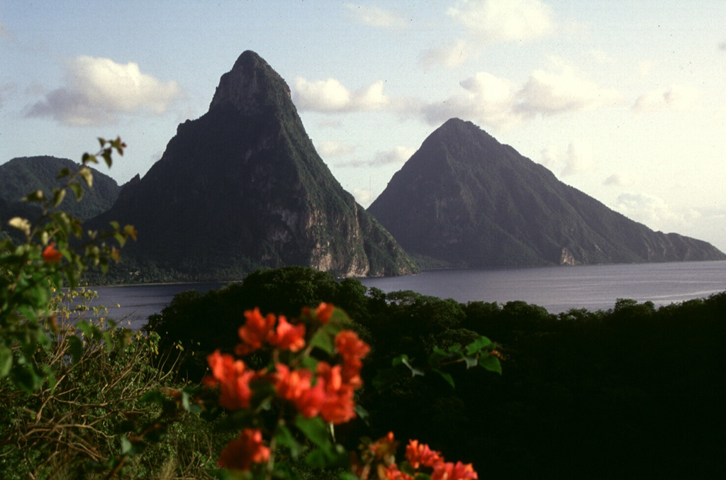 The twin lava domes of the Pitons rise above Soufriere Bay on St. Lucia, forming one of the scenic highlights of the West Indies.  Petit Piton (left) and Gros Piton (right) are the eroded plugs of 250,000-year-old dacitic lava domes preceding formation of  the 3.5 x 5 km Qualibou caldera about 32-39,000 years ago.  The only known Holocene activity at Qualibou was a minor phreatic eruption in the Sulfur Springs thermal area in 1766 CE that ejected a thin ash layer over a wide area.    Photo by Lee Siebert, 1991 (Smithsonian Institution).