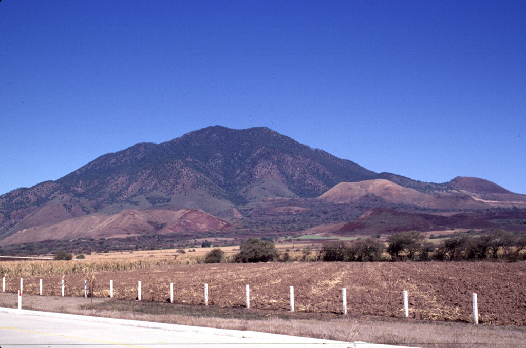 Multiple scoria cones have formed across the flanks of Sangangüey. The light-colored cone below the skyline and to the right is cone C4, and the darker cone on the lower right horizon is D8. These two cones are part of the youngest group of cones and may be only 1,000 years old. A lava flow from the C4 crater traveled down the south flank of Sangangüey between the two older cones of B3 and B4, in the foreground. Photo by Lee Siebert, 1997 (Smithsonian Institution).
